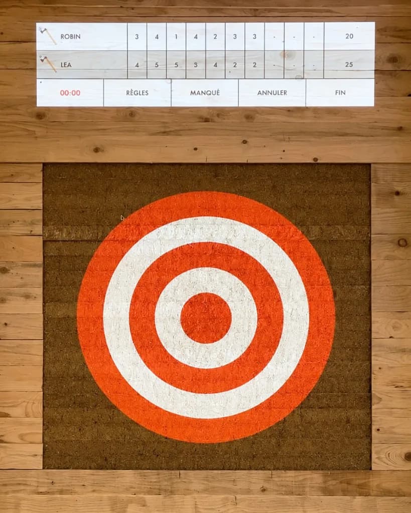Une cible de compétition projetée sur une plaque de coco, avec la table des scores au-dessus