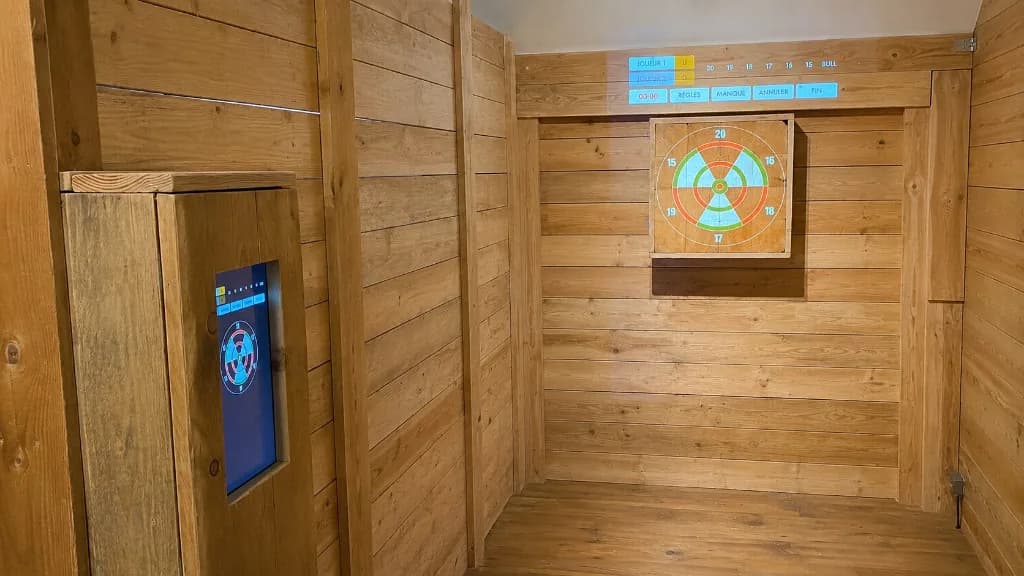 Un couloir de lancer équipé de DigiThrow : cible projetée sur le bois et écran tactile encastré dans la cloison